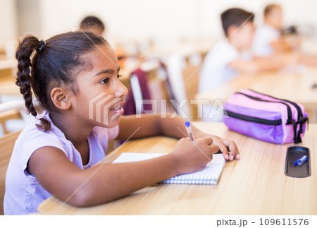 Portrait of arabian girl who is posing at the desk in classroom elementary school 109611576