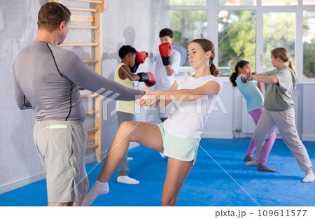 Girl and her trainer learn how to deliver painful blows during self defense training. 109611577