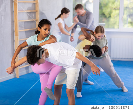 African teenage girl practicing wristlock with elbow and knee blows in sparring with boy African teenage girl practicing wristlock with elbow and knee blows in sparring with boy 109611871