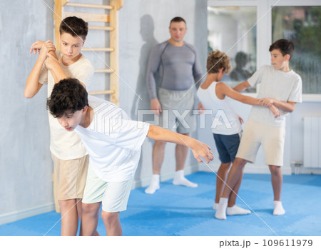 Teenagers practicing painful armlock in sparring at self defence training 109611979