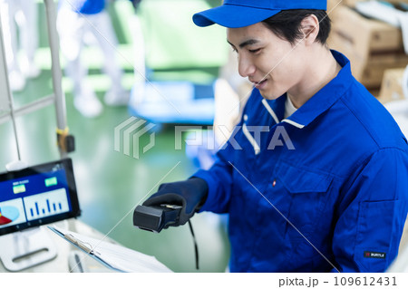 出荷リストを確認する若いロジスティクスんのスタップ 109612431