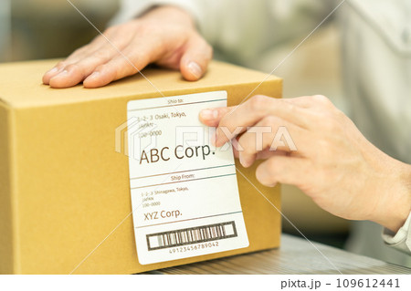 出荷ラベルを貼り付ける男性作業員 顔無し 出荷ラベルを貼り付ける男性作業員 顔無し 109612441