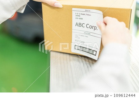 出荷ラベルを貼り付ける女性作業員 顔無し 出荷ラベルを貼り付ける女性作業員 顔無し 109612444