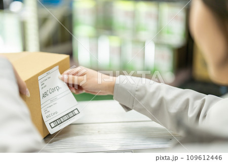 出荷ラベルを貼り付ける女性作業員　顔無し 109612446