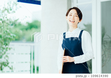 カフェの店内に案内する女性 109614390