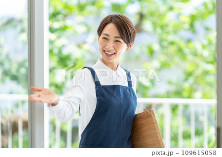 カフェの店内に案内する女性 109615058