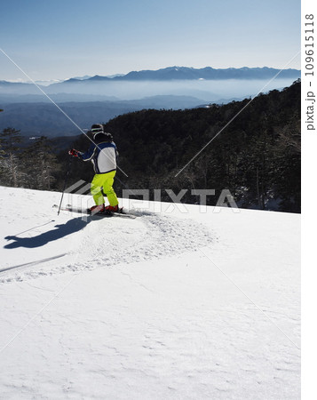 快晴の開田高原マイヤスキー場にて中央アルプスに向って滑走するスキーヤー 快晴の開田高原マイヤスキー場にて中央アルプスに向って滑走するスキーヤー 109615118