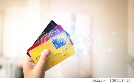 Close up of hand holding credit or debit card with padlock, protection of financial transactions Close up of hand holding credit or debit card with padlock, protection of financial transactions 109615416