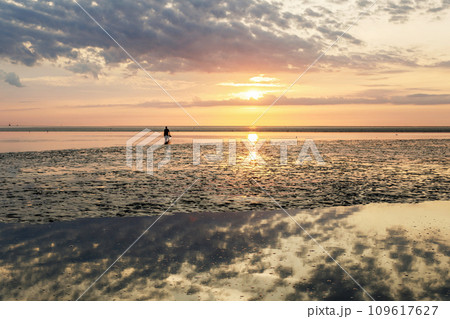 Wattenmeer, mud tideland in North Sea, Germany. Nordsee, Watt by sunset. Wattenmeer, mud tideland in North Sea, Germany. Nordsee, Watt by sunset. 109617627
