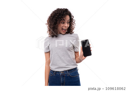 portrait of a young surprised joyful 30 year old caucasian woman in a gray t-shirt holding a 109618062