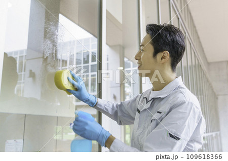 オフィスで窓の掃除をする男性清掃員　撮影協力：有明教育芸術短期大学 109618366