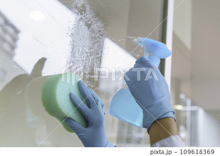 オフィスで窓の掃除をする男性清掃員の手元のアップ　撮影協力：有明教育芸術短期大学 109618369