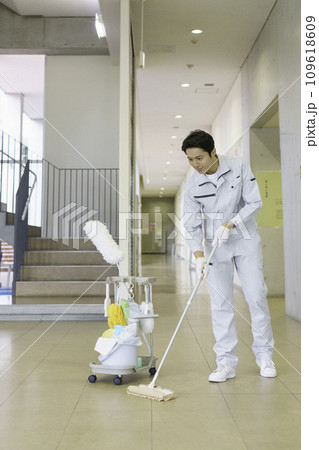 オフィスビルで床を拭く男性清掃員　縦位置　撮影協力：有明教育芸術短期大学 109618609