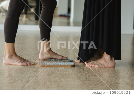close-up of the legs of girls engaged in standing on a board with nails barefoot 109619321