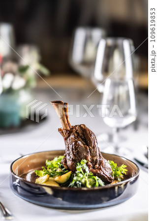 Confit leg of lamb on mashed potatoes with creamy kale, demi glace sauce and herbs in the hotel restaurant 109619853