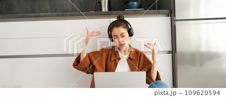 Excited young woman, programmer achieves goal, triumphing, winning on laptop, sitting in headphones, dancing with hands, celebrating victory Excited young woman, programmer achieves goal, triumphing, winning on laptop, sitting in headphones, dancing with hands, celebrating victory 109620594