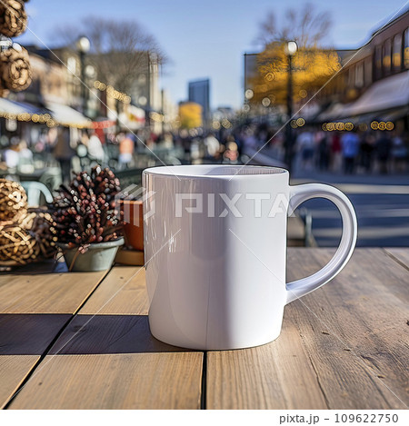 white simple coffee cup without decorations on a rustic wooden table in front of a blurred background with an urban scene 109622750