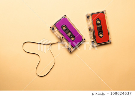 Overhead view of two colourful cassette tapes on beige background 109624637