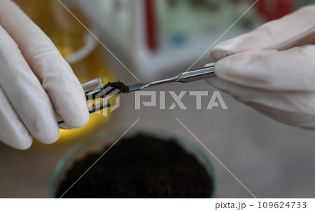 Researcher holds glass flask with earth in hand Researcher holds glass flask with earth in hand 109624733