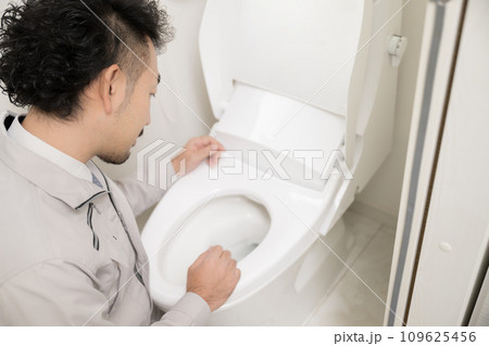 トイレを掃除やつまりを確認する業者の人 109625456