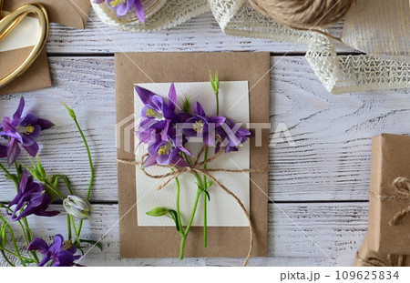 Pink and blue flowers, postcard, kraft, twine. Layout of Women's Day or Mother's Day, St. Valentine's Day, flat, top view. Pink and blue flowers, postcard, kraft, twine. Layout of Women's Day or Mother's Day, St. Valentine's Day, flat, top view. 109625834