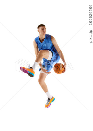 Dynamic image of young man, basketball player in motion, jumping with ball, scoring winning goal isolated over white background. Sport concept Dynamic image of young man, basketball player in motion, jumping with ball, scoring winning goal isolated over white background. Sport concept 109626506