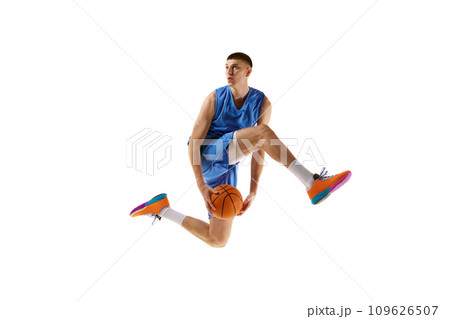 Dynamic image of young man, basketball player in motion, jumping with ball, scoring winning goal isolated over white background. Sport concept Dynamic image of young man, basketball player in motion, jumping with ball, scoring winning goal isolated over white background. Sport concept 109626507