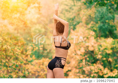 Beautiful young woman in lingerie in autumn forest 109627041