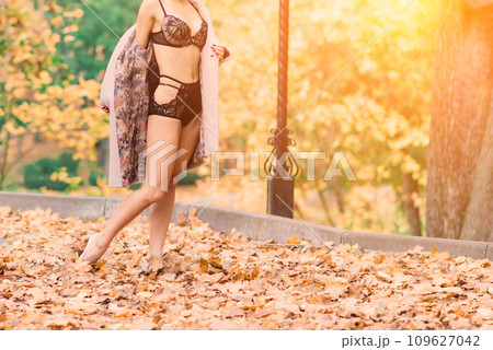 Sexy brunette female in autumn forest, public park. Sport, slender body 109627042