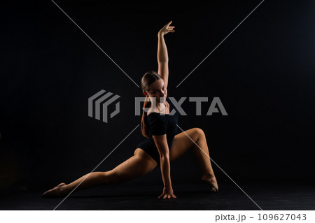 Beautiful plump brown-haired woman in black bodysuit in a studio. Caucasian dancehall dancer posing 109627043