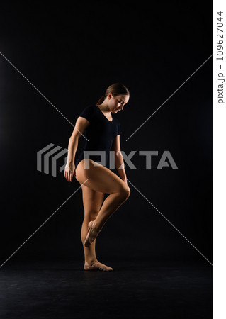 Beautiful plump brown-haired woman in black bodysuit in a studio. Caucasian dancehall dancer posing 109627044