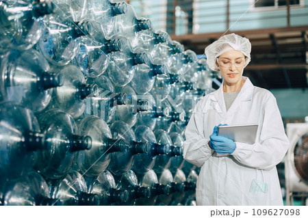 Women worker working in drinking water factory inspect counting bottle stock warehouse check counting with hygiene uniform. 109627098