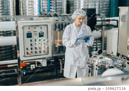 hygiene staff worker in foods and drinks clean factory. working women in water plant industry quality control check. 109627116