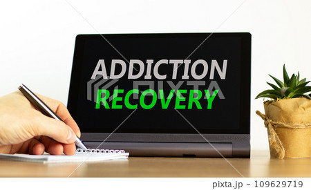 Addiction recovery symbol. Concept words Addiction recovery on beautiful black tablet. Beautiful white background. Psychologist hand. Psychology addiction recovery concept. Copy space. 109629719