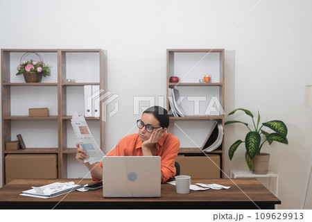 Bored woman holds domestic expenses involved in financial paperwork female manages monthly banking payments summarizing utility bills of living in own apartment Bored woman holds domestic expenses involved in financial paperwork female manages monthly banking payments summarizing utility bills of living in own apartment 109629913