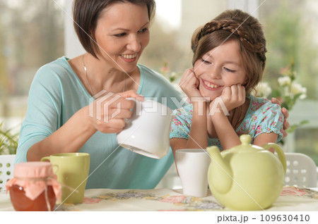 Happy mom and daughter drinking tea at home 109630410