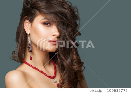 Fashionable young brunette jewelry model portrait. Woman with long brown wavy hair, natural makeup Fashionable young brunette jewelry model portrait. Woman with long brown wavy hair, natural makeup 109632775