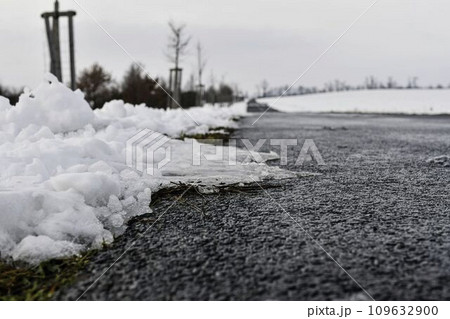 Road ploughed through by snow plough in winter. The concept of winter and winter road service Road ploughed through by snow plough in winter. The concept of winter and winter road service 109632900