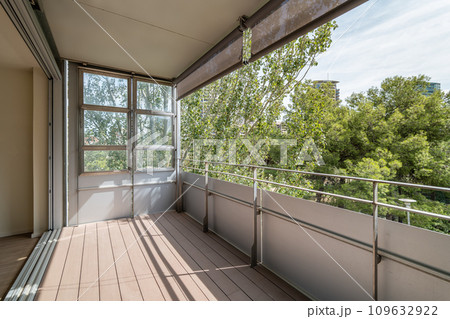 Large long loggia in apartment with view of green trees Large long loggia in apartment with view of green trees 109632922