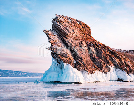 Ogoy island on winter Baikal lake. Winter scenery of Dragon Tail Rock on Ogoy island during sunrise at Lake Baikal. Ogoy island on winter Baikal lake. Winter scenery of Dragon Tail Rock on Ogoy island during sunrise at Lake Baikal. 109634209