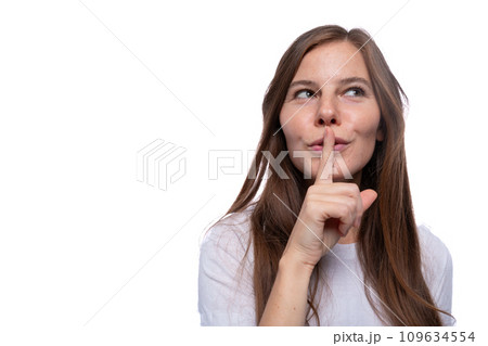 Young woman keeping a secret and covering her mouth with her finger 109634554