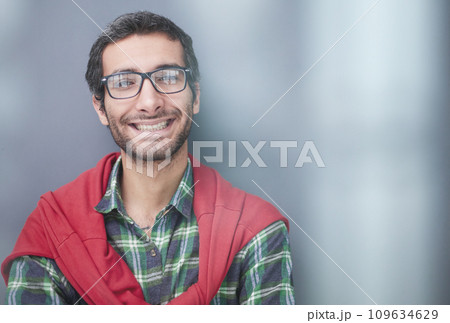 Smiling handsome man in shirt standing with crossed arms on gray background Smiling handsome man in shirt standing with crossed arms on gray background 109634629