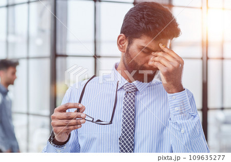 Businessman in a blue shirt and glasses in his hand 109635277