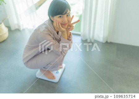 体重を計る20代の女性 109635714