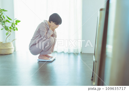 体重を計る20代の女性 体重を計る20代の女性 109635717