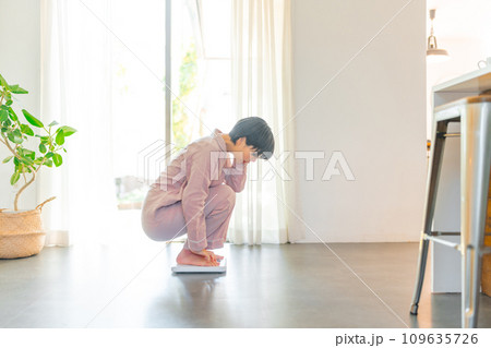 体重を計る20代の女性 体重を計る20代の女性 109635726