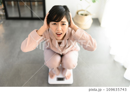 体重を計る20代の女性 体重を計る20代の女性 109635743