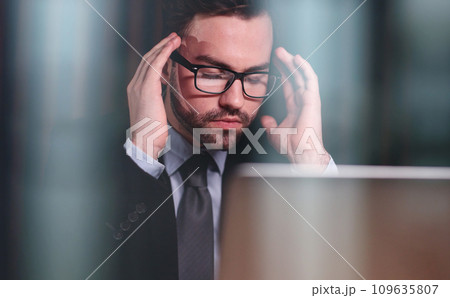 Tired man behind a computer screen from boring routine work in the office. Tired man behind a computer screen from boring routine work in the office. 109635807