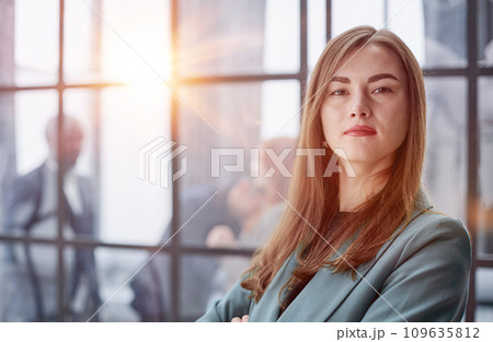Portrait of a confident young businesswoman standing with her arms crossed in an office Portrait of a confident young businesswoman standing with her arms crossed in an office 109635812