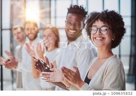 Group of businesspeople sitting in a line and applauding. Group of businesspeople sitting in a line and applauding. 109635832